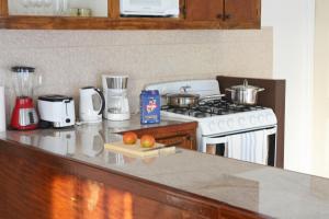 a kitchen with a stove and a counter with some food at Blue Sky Apartment in Soufrière +3 photos