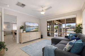 a living room with a couch and a tv at Canal escape with private jetty and huge deck in South Yunderup
