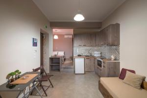 a kitchen and living room with a couch and a table at Margarita Rooms Sagiada in Sagiada