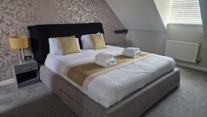 a bedroom with a large bed with towels on it at Greatmindz abode in Kingshurst