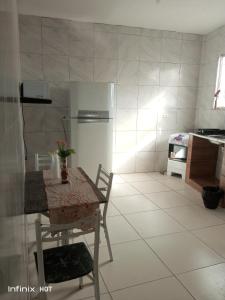 a kitchen with a table and a refrigerator at Próximo do carnaval em Olinda in Olinda