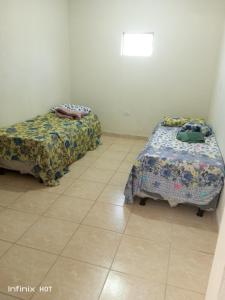 two beds in a room with a tiled floor at Próximo do carnaval em Olinda in Olinda