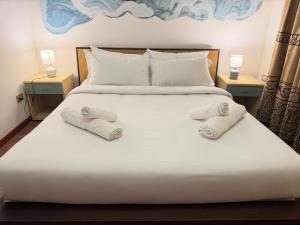 a large white bed with two towels on it at Victoria guesthouse in Rome