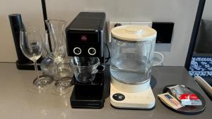 a blender sitting on a counter next to wine glasses at Premium Smart Studio with River View in Tbilisi City