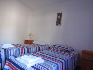 two beds in a hotel room with towels on them at casitadearminda in Villa Las Rosas