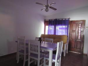 a dining room with a table and chairs and a couch at casitadearminda in Villa Las Rosas