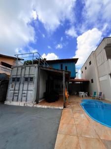 a house with a swimming pool and a building at Conteiner House in Pipa