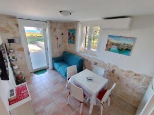 a living room with a table and a blue couch at Alba e Colori di Puglia in Conversano