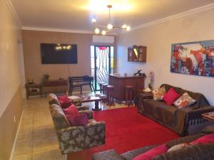 a living room with two couches and a television at Quarto suite 1 dorm Prox da Casa de Saude mais salas e estacionamento in Santa Maria