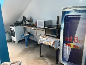 a kitchen with a soda machine and a table in a room at Cantinho dos netos-suites próximo ao Sesc em Bertioga in Bertioga