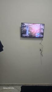 a flat screen tv hanging on a white wall at Cantinho dos netos-suites próximo ao Sesc em Bertioga in Bertioga