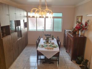 a dining room with a table and a chandelier at Quarto suite 1 dorm Prox da Casa de Saude mais salas e estacionamento in Santa Maria
