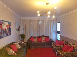 a living room with two couches and a chandelier at Quarto suite 1 dorm Prox da Casa de Saude mais salas e estacionamento in Santa Maria