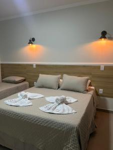 a bedroom with two beds with towels on them at Pousada Vila Palmital in Paraty