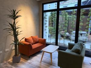 a living room with two chairs and a plant at Hangkhau Hotel in Yilan City