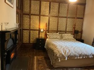 a bedroom with a large bed and a fireplace at Bromwich Guest House - 250m to town centre! in Blackwood