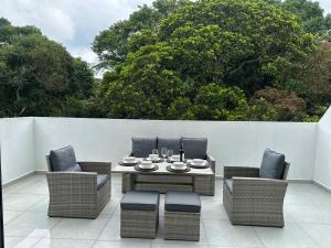 a patio with a table and chairs and a fence at Apartamento duplex villa 19 de lujo in Armenia