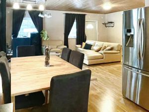 a kitchen and living room with a table and a refrigerator at 8 person holiday home in Mönsterås in Mönsterås
