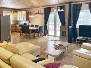 a living room with a yellow couch and a kitchen at 8 person holiday home in Mönsterås in Mönsterås