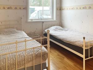 two beds in a room with a window at 8 person holiday home in Mönsterås in Mönsterås
