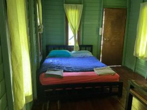 a bed in a green room with a window at Green Garden Bungalow Resort in Ban Khlong Kloi