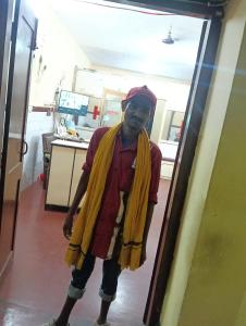 a man wearing a yellow cape standing in a room at Hotel Swapnapuri in Bhubaneshwar
