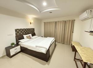 a bedroom with a large bed in a room at Tanour lux service apartment in Bangalore