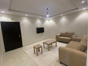 a living room with two couches and a flat screen tv at مساكن اركان in Quai