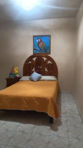 a bedroom with a bed with a wooden headboard at Hotel Ricarda Yopes Acapulco in Acapulco +15 photos