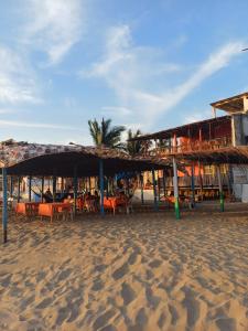 a restaurant with tables and chairs on a beach at Hotel Ricarda Yopes Acapulco in Acapulco