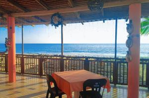 a table and chairs on a balcony with the ocean at Hotel Ricarda Yopes Acapulco in Acapulco