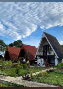 a house with a red roof on a field at VILA RINJANI PARADAIS IIn in Sajang