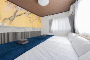 a bedroom with a large white bed and a window at A Family Friendly Spacious Villa - Easy to Tokyo Station & Conveniently Located for Tokyo Disney Resort & 1 min to Convenience Store in Tokyo