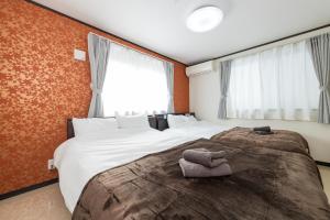 a bedroom with a large bed with towels on it at A Family Friendly Spacious Villa - Easy to Tokyo Station & Conveniently Located for Tokyo Disney Resort & 1 min to Convenience Store in Tokyo +58 photos