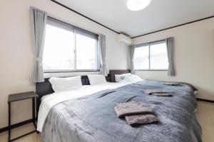 a bedroom with a large bed with two towels on it at A Family Friendly Spacious Villa - Easy to Tokyo Station & Conveniently Located for Tokyo Disney Resort & 1 min to Convenience Store in Tokyo