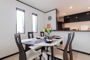 a dining room with a white table and chairs at A Family Friendly Spacious Villa - Easy to Tokyo Station & Conveniently Located for Tokyo Disney Resort & 1 min to Convenience Store in Tokyo