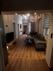a living room with a couch and a flat screen tv at The Hidden Heaven in Chios