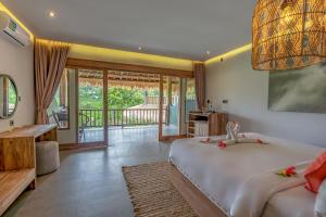 a bedroom with two beds and a balcony at Sweet Escape - Boutique Hotel in Sidemen