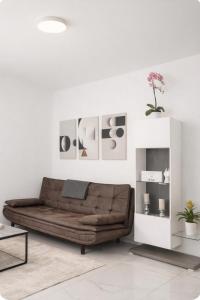 a living room with a brown leather couch at Kleine Auszeit in Friedrichshafen +2 photos
