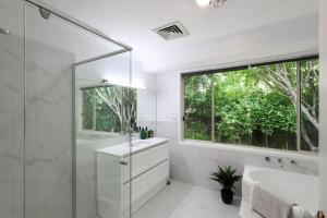 a bathroom with a sink and a shower and a window at Linden Getaway Bowral in Bowral +20 photos