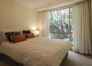 a bedroom with a large bed and a large window at Linden Getaway Bowral in Bowral