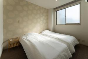 a bedroom with two beds and a window at 野町 庵 in Kanazawa