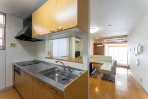 a kitchen with a sink and a living room at 野町 庵 in Kanazawa