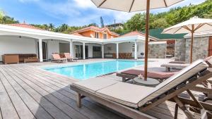 a villa with a swimming pool and a house at Villa La Ressource in Le François