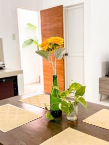 a green bottle with flowers in it on a table at LAD Private Reosrt in Dasmariñas