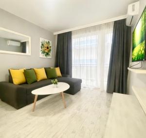 a living room with a couch and a table at ESKADA Apartments in Ahtopol