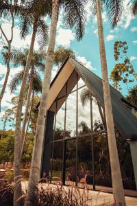 a building with palm trees in front of it at Cabana Sabá in Ibiúna