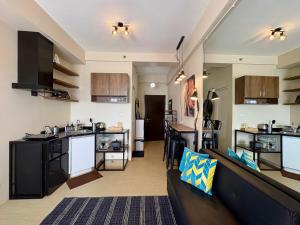 a living room with a couch and a kitchen at A city escape at the Avida Towers Aspira 1 in Cagayan de Oro