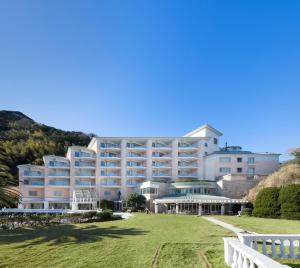 ein großes weißes Hotel mit einem Rasen davor in der Unterkunft Awashima Hotel in Numazu
