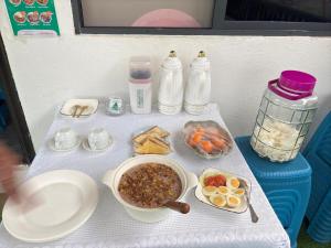 a table with food and drinks on it at JE Garden Guesthouse in Oecusse RAEOA in Deli